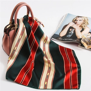 Elegant striped silk square scarf draped on a pink handbag with retro color blocks