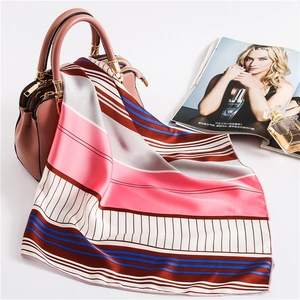Detailed view of a colorful striped silk scarf elegantly draped over a pink handbag