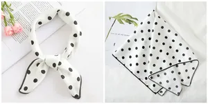 Detail of white satin scarf with black polka dots featuring fine edge stitching detail