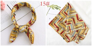 Detail of yellow silk-like square scarf featuring retro chain and belt print patterns