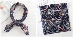 Detail of a navy blue silk scarf with vintage carriage wheel and chain patterns