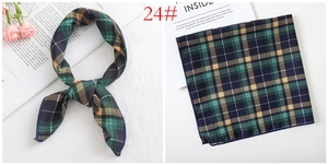 Detailed view of a classic plaid satin silk scarf with navy, green, and yellow patterns