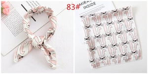 Detail of pink silk square scarf featuring cute rabbit prints and glossy satin texture