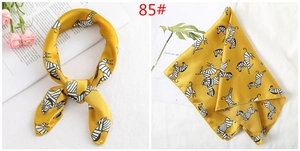 Detail of yellow silk scarf with zebra pattern tied and folded for styling inspiration
