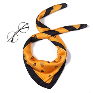 Detail of silk-like square scarf with yellow stripes and black camellia floral patterns