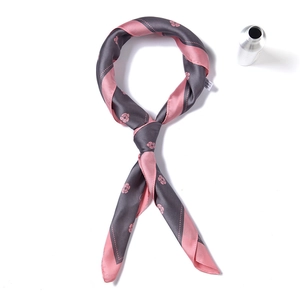 Detailed shot of striped floral silk scarf showing soft satin texture and elegant knots