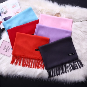 Close-up of assorted colorful cashmere scarves with elegant fringe and woven labels