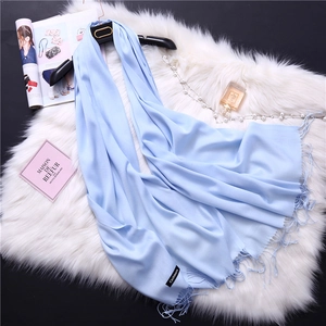 Detail view of light blue cashmere scarf with elegant fringe texture and accessories