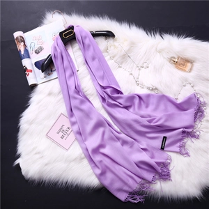 Detail of lavender cashmere scarf with soft fringes and professional woven label