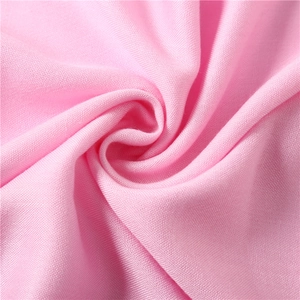 Macro shot of light pink cashmere-like fabric showing fine weave texture and soft drape
