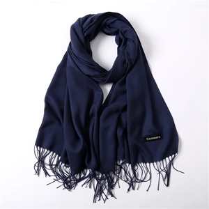 Close-up of deep blue cashmere shawl with soft fringe details and authentic quality label