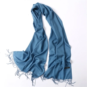 Close-up of deep sky blue pashmina scarf with soft tassels and cashmere fabric label