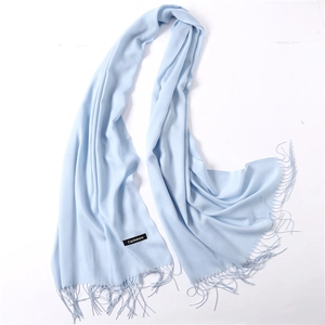 Detail of light blue cashmere scarf showing fine tassel fringe and material label