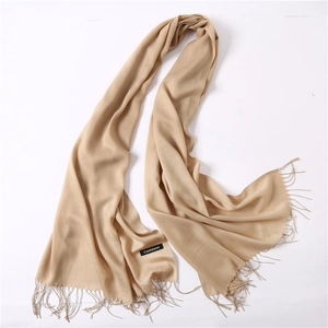 Detailed texture of beige cashmere scarf featuring elegant fringed edges and soft finish