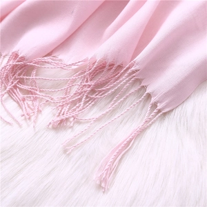 Detail view of light pink cashmere-like scarf with soft fringe edges and fine texture