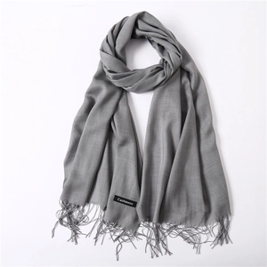 Close-up of soft grey cashmere scarf texture with delicate fringe edge detail