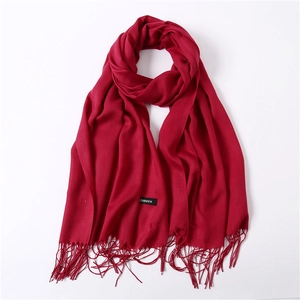Detailed macro view of vibrant red pashmina scarf fringe and soft woven textile texture