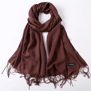 Detail of burgundy cashmere shawl showing woven texture, fine tassels and label