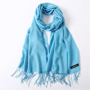 Close-up of bright blue cashmere scarf showing fine plain weave texture and fringe detail
