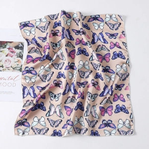 Detail view of square silk scarf featuring colorful butterfly print and fine stitched edges