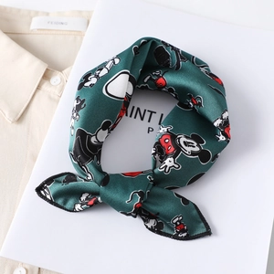 Detail view of smooth green silk scarf featuring classic cartoon mouse prints on white background