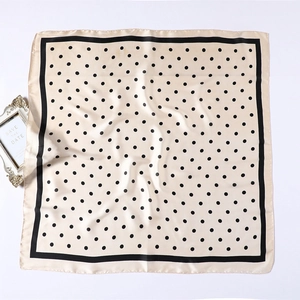 Detailed view of beige satin scarf with classic black polka dots and border
