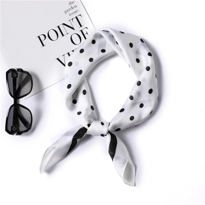Detail of silk-satin scarf with black polka dots, styled with sunglasses and card