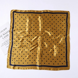Detail of silk-satin square scarf with vintage navy polka dots on a golden yellow base