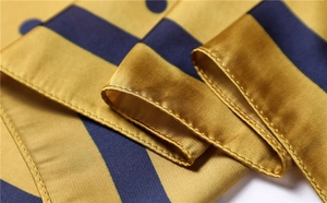 Detailed macro view of high-quality silk satin scarf with polka dots and hemmed edges