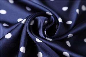 Macro detail of navy blue satin silk scarf with elegant white polka dots pattern