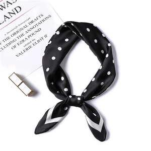 Macro detail of silk-like satin neck scarf with stylish black and white polka dot patterns