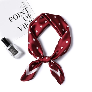 Detail of silk satin wine red neckerchief with white polka dots near fashion magazine