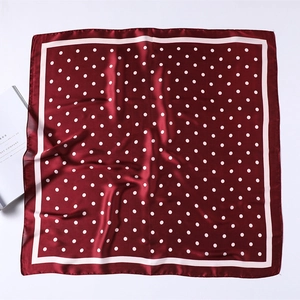 Detailed view of dark red satin silk scarf with white polka dots and elegant sheen