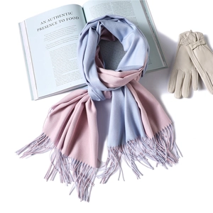Detail of soft cashmere-feel scarf with blue and pink bicolor design and delicate tassels