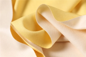 Detail of soft yellow and beige cashmere-feel scarf showing fine twill weave texture