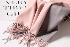 Close-up of pink and grey reversible cashmere-like scarf with long fringe details
