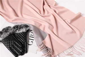 Detail of pink and grey cashmere-like scarf with fringe and quilted leather gloves