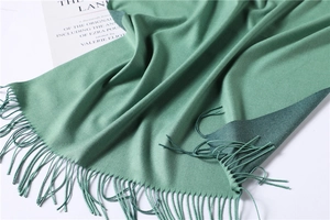 Detail of double-sided grass green cashmere shawl with fringe and soft texture