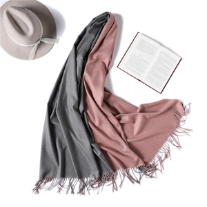 Detail of double-sided cashmere scarf in grey and pink with delicate tassel fringe