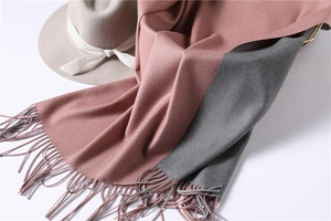 Detailed texture of dual-color pink and grey cashmere-like scarf with fringe edges
