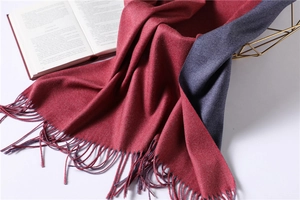 Detail of burgundy and dark blue cashmere scarf showing thick texture and long tassels