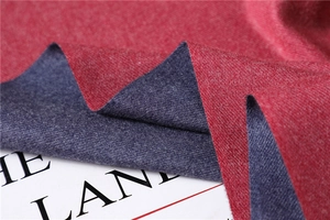 Detail of red and charcoal reversible cashmere-feel scarf with soft knitted texture