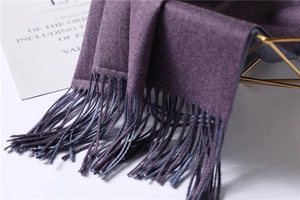 Detailed close-up of dark purple and grey cashmere-like scarf with fringe accents