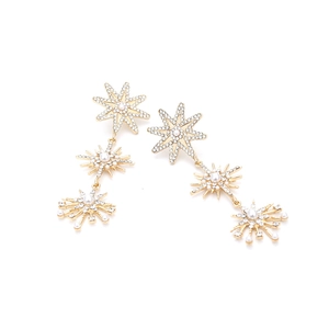 Detail of gold star drop earrings with white pearls and sparkling rhinestones