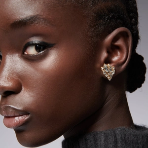 Golden flower tassel earrings with clear crystals shown on model in side profile