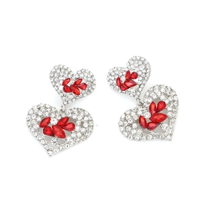 Gros plan de boucles d'oreilles cœur argentées avec strass et pierres marquises rouges