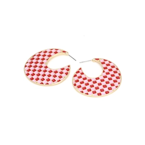 Detailed view of C-shaped hoop earrings featuring red and pink checkered enamel patterns