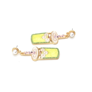 Close-up of creative yellow milk tea cup earrings with colorful rhinestones and pearls
