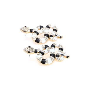 Détail de boucles d'oreilles serpent avec strass brillants et rayures en émail noir et blanc