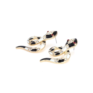 Detail of snake earrings with black white enamel and red crystal eyes on gold base
